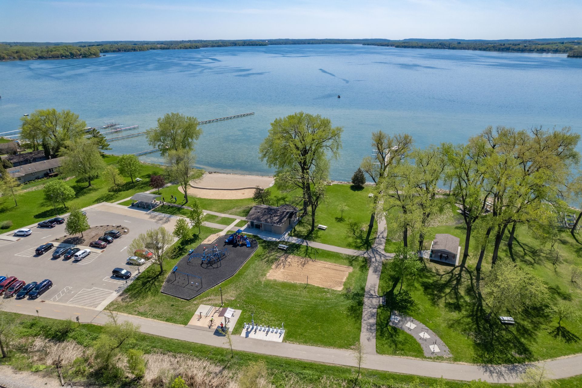 an aerial view of a park with a lake in the background