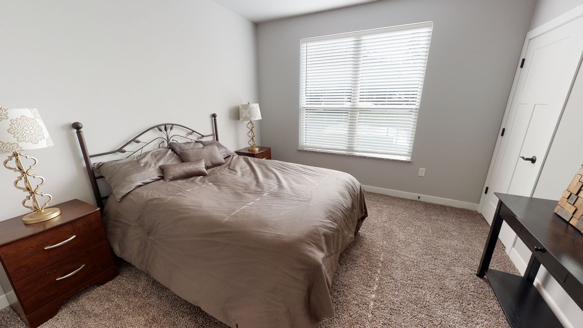 a bedroom with a bed and a window with blinds