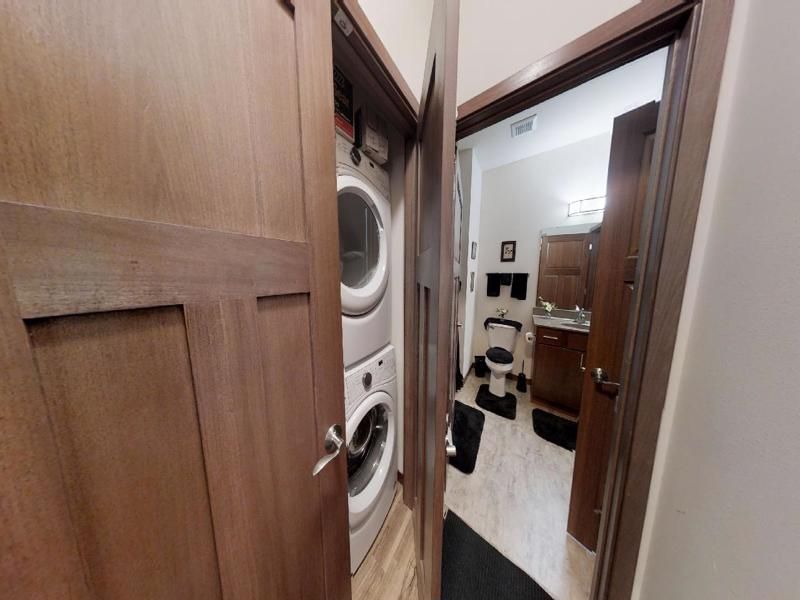a bathroom with a washer and dryer stacked on top of each other