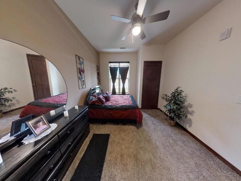 a bedroom with a bed and a ceiling fan