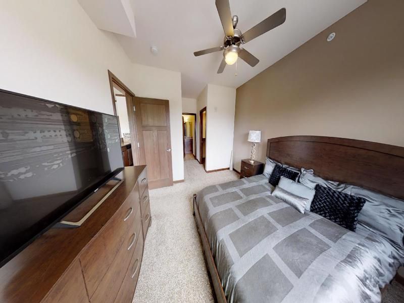 a bedroom with a large bed and a flat screen tv