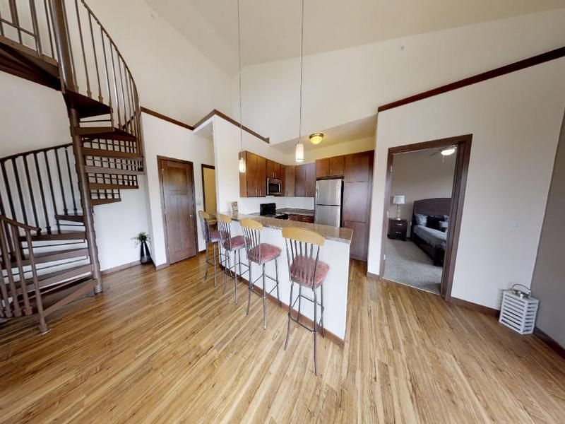 a kitchen with a spiral staircase leading up to the second floor