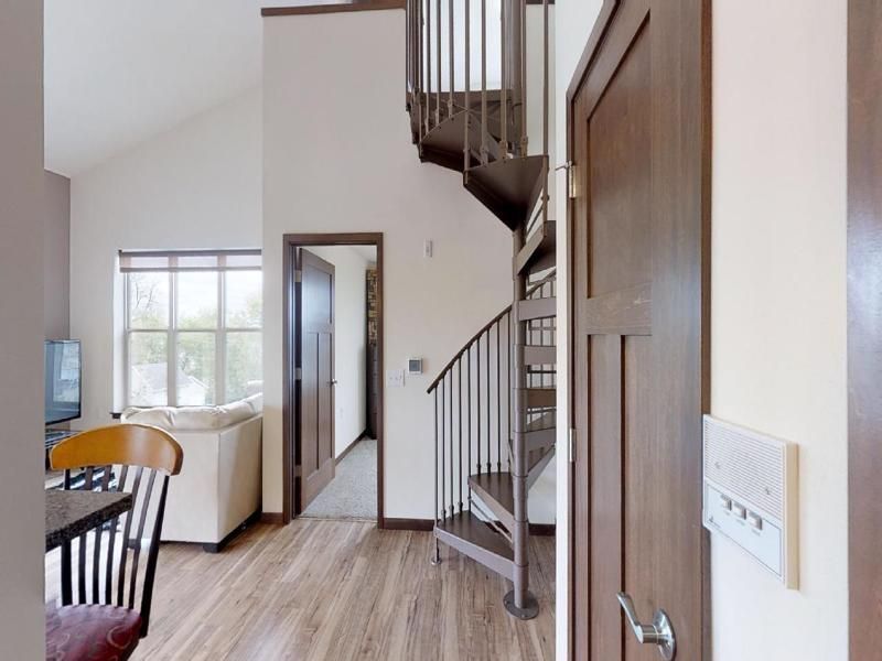 a living room with a spiral staircase leading up to the second floor