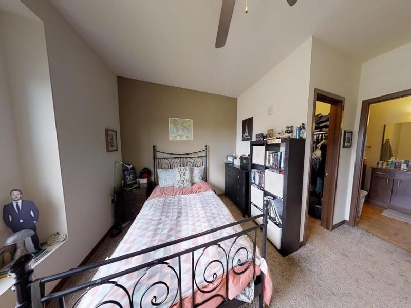 a bedroom with a bed and a shelf with a picture of a man on it