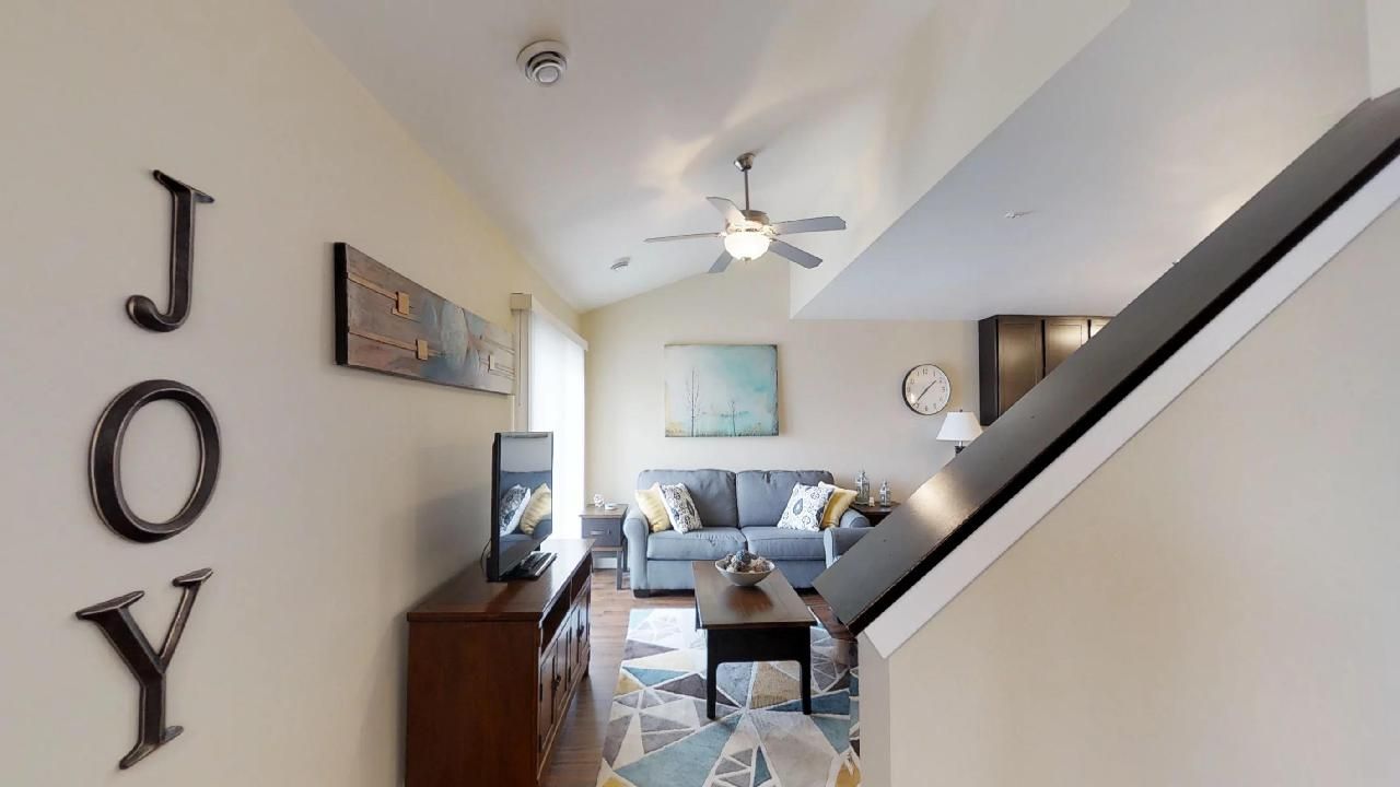 a living room with a couch and a ceiling fan