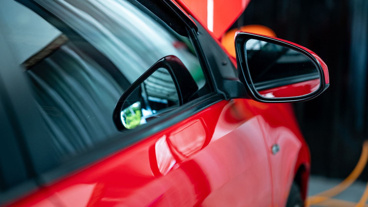 Car mirror glass replacement technician installing replacement mirror glass on a vehicle. Car mirror glass replacement technician installing replacement mirror glass on a vehicle.