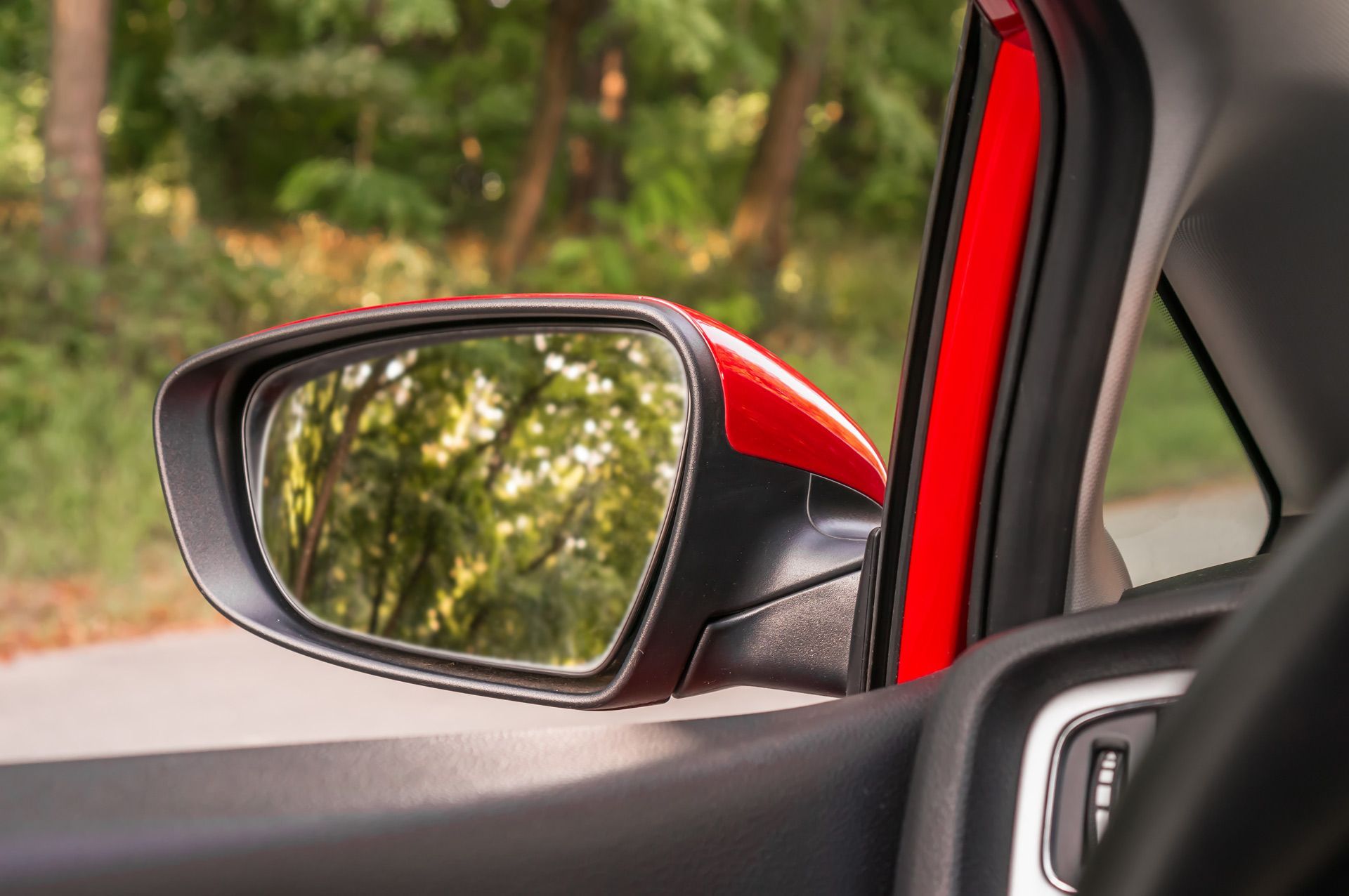 Close-up on the reflection of a rearview car mirror.