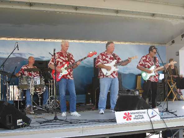 A group of men are playing guitars on a stage.