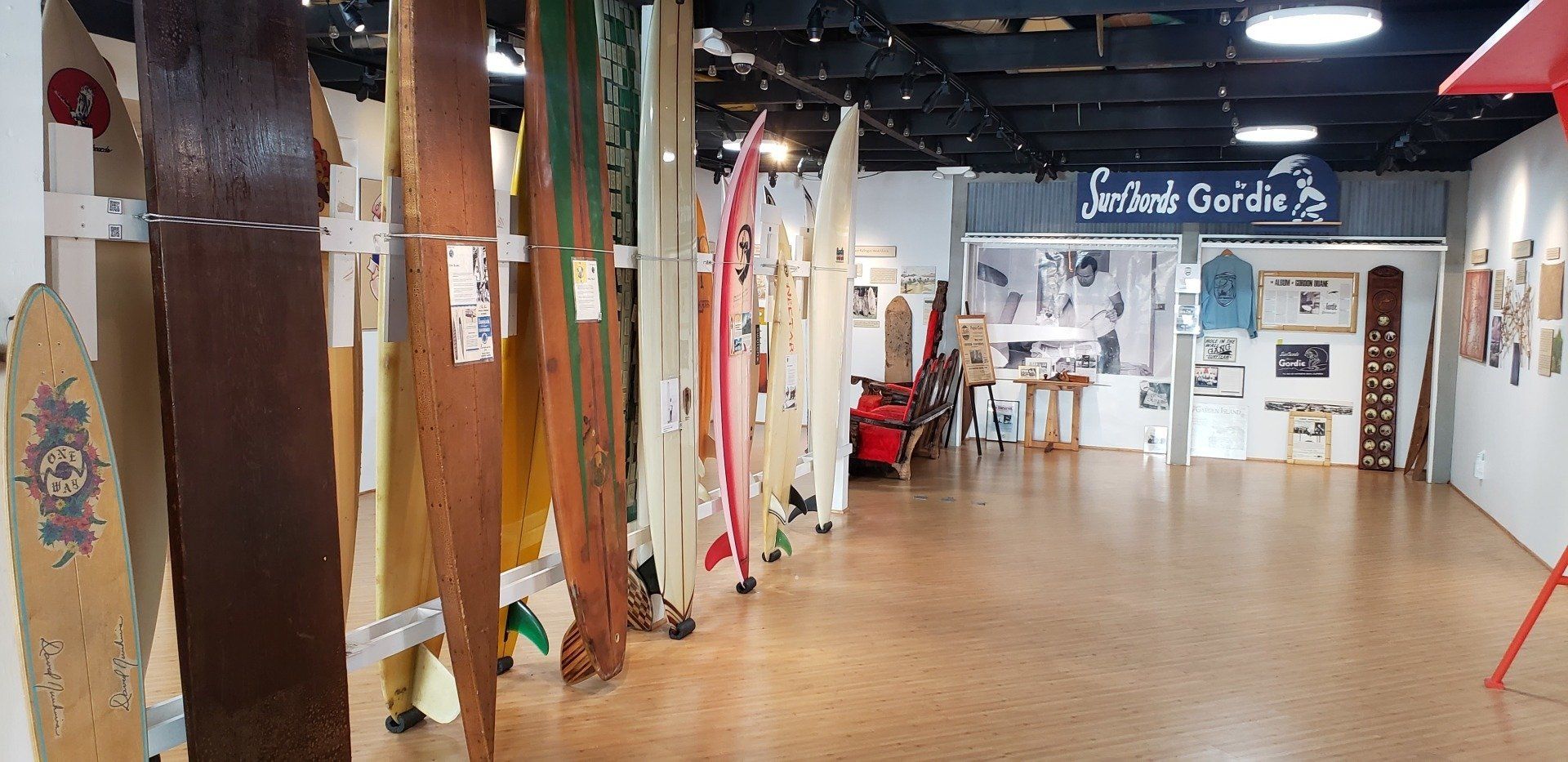A row of surfboards are lined up in a room.