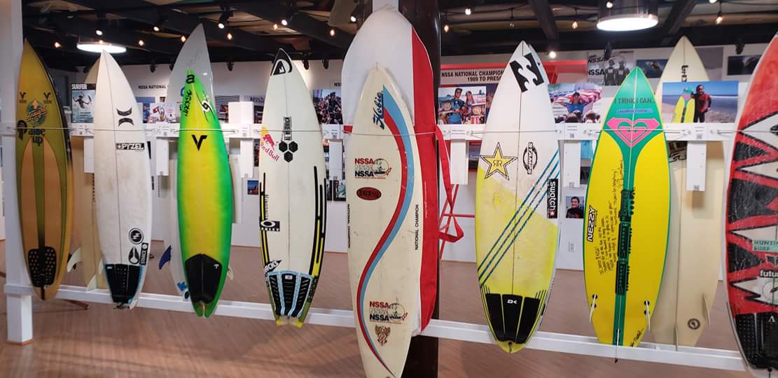A bunch of surfboards are lined up in a room.