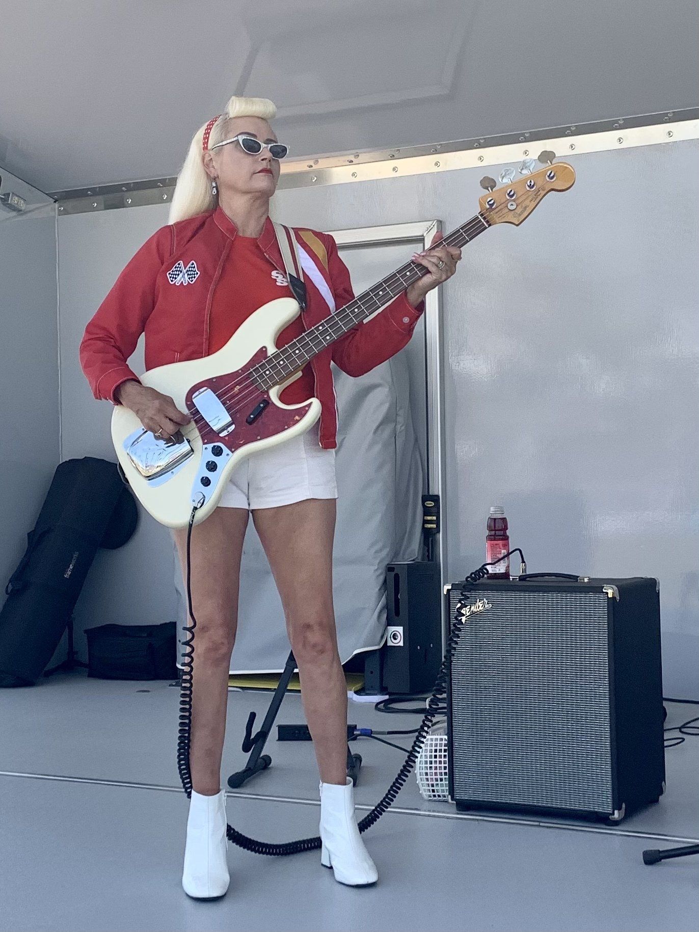 A woman is standing on a stage playing a guitar.