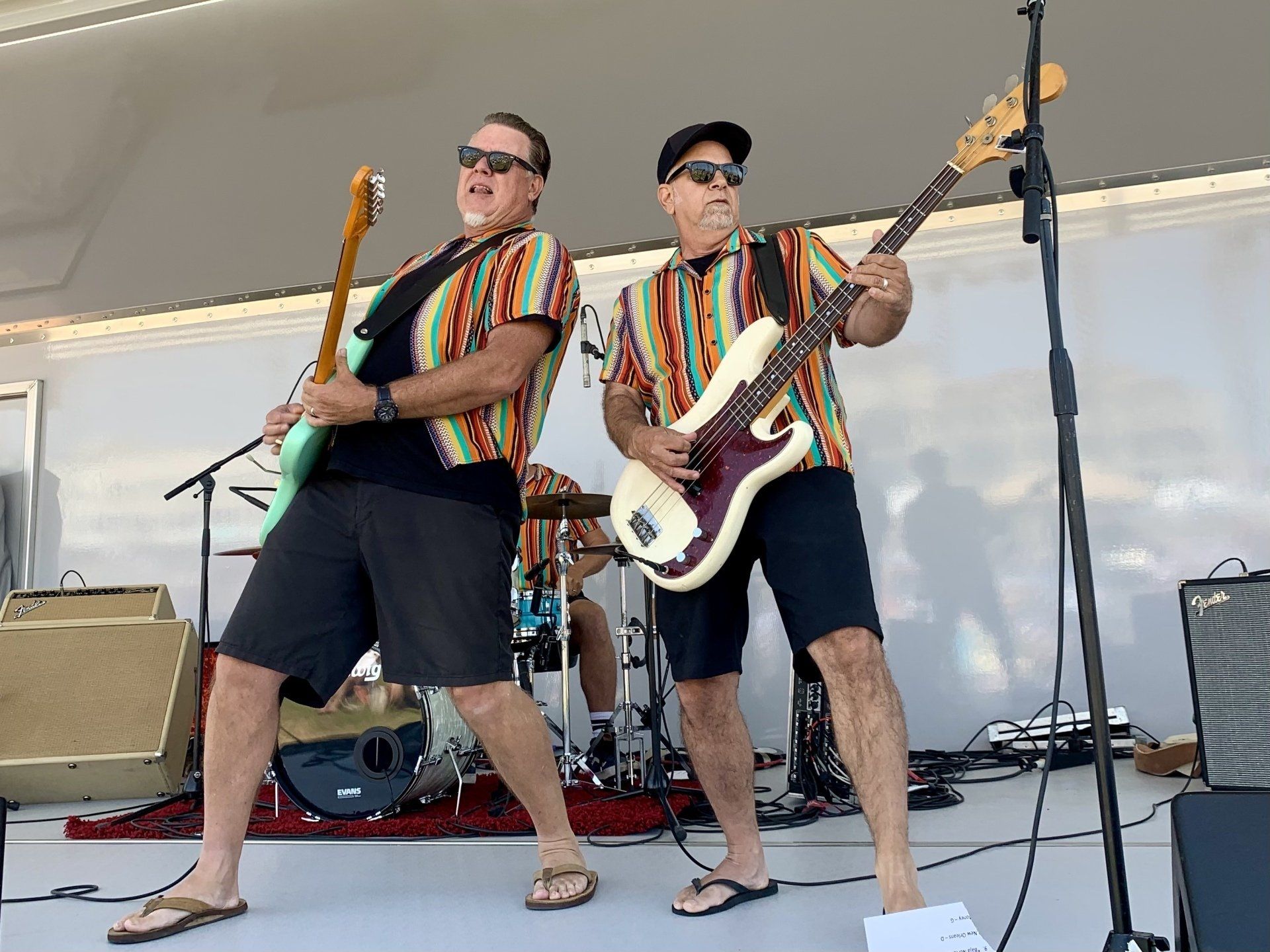 Two men are playing guitars on a stage.