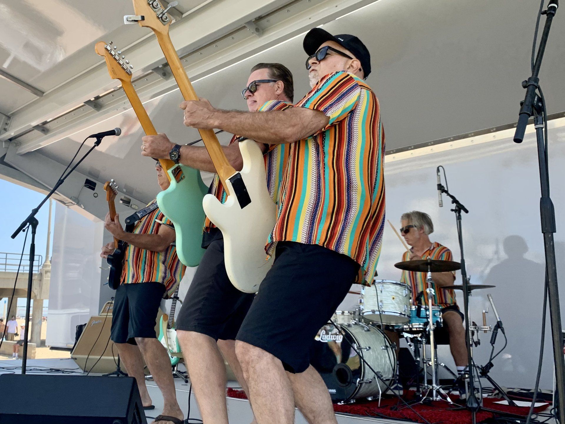 A group of men are playing guitars on a stage.