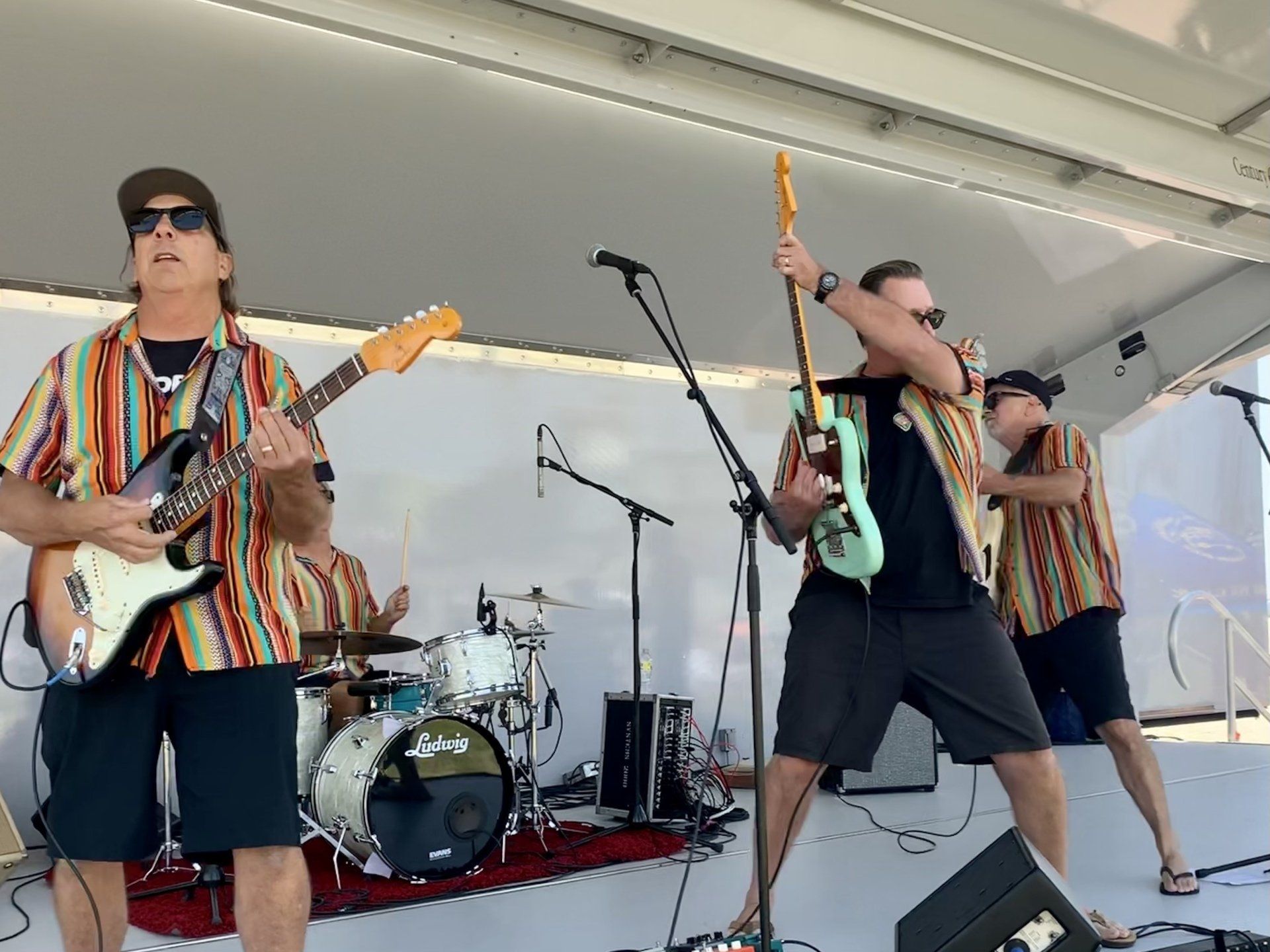A group of men are playing guitars on a stage.