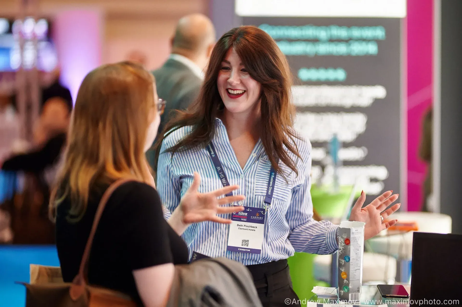 Two women are sitting at a table talking to each other.