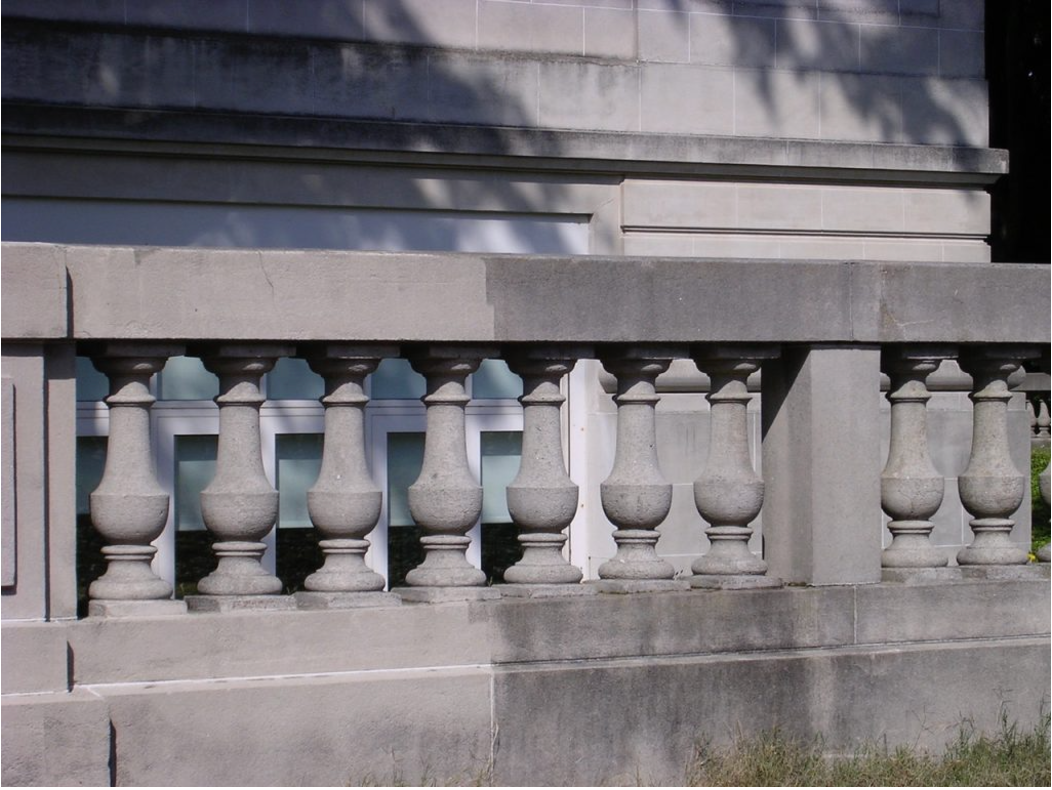 A stone railing is sitting in front of a building