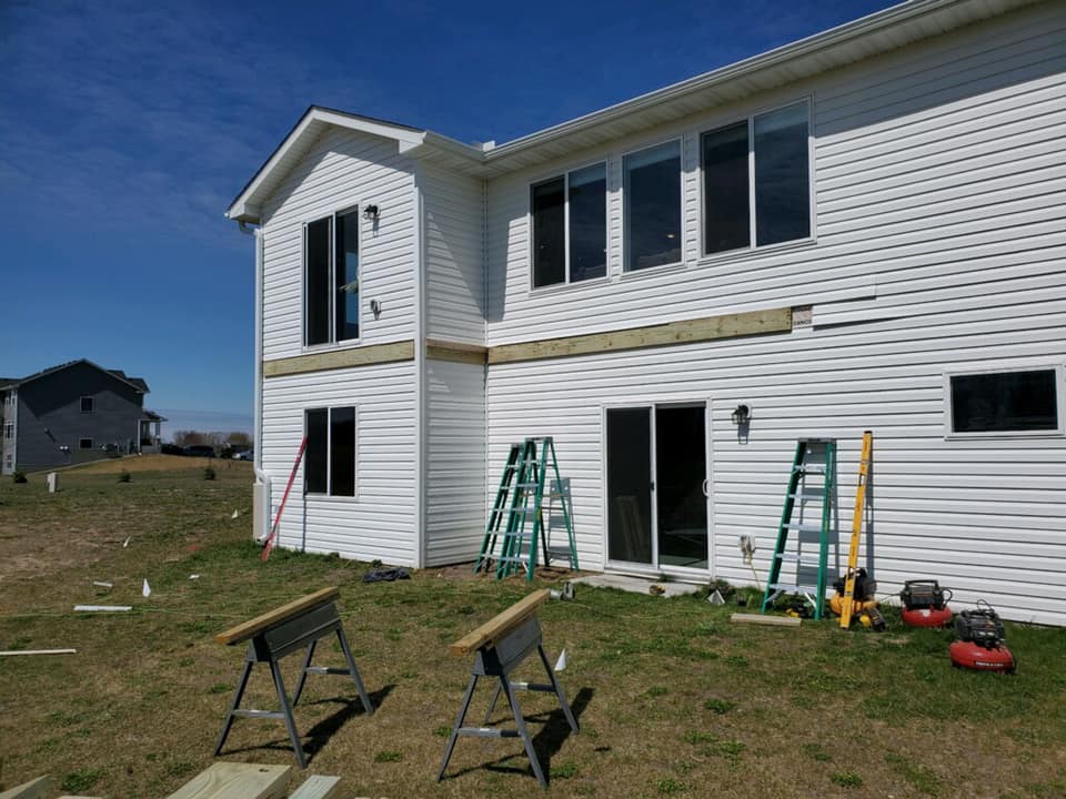 Construction of wooden deck attached to white house