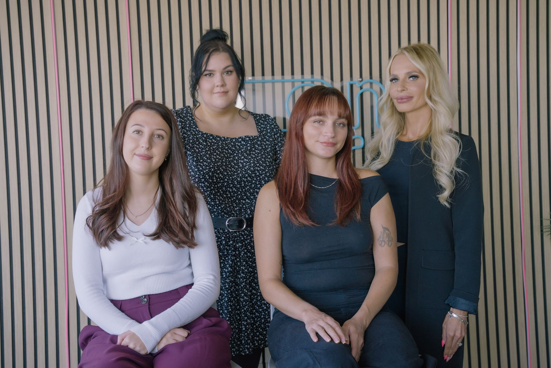 Four women in front of striped wall