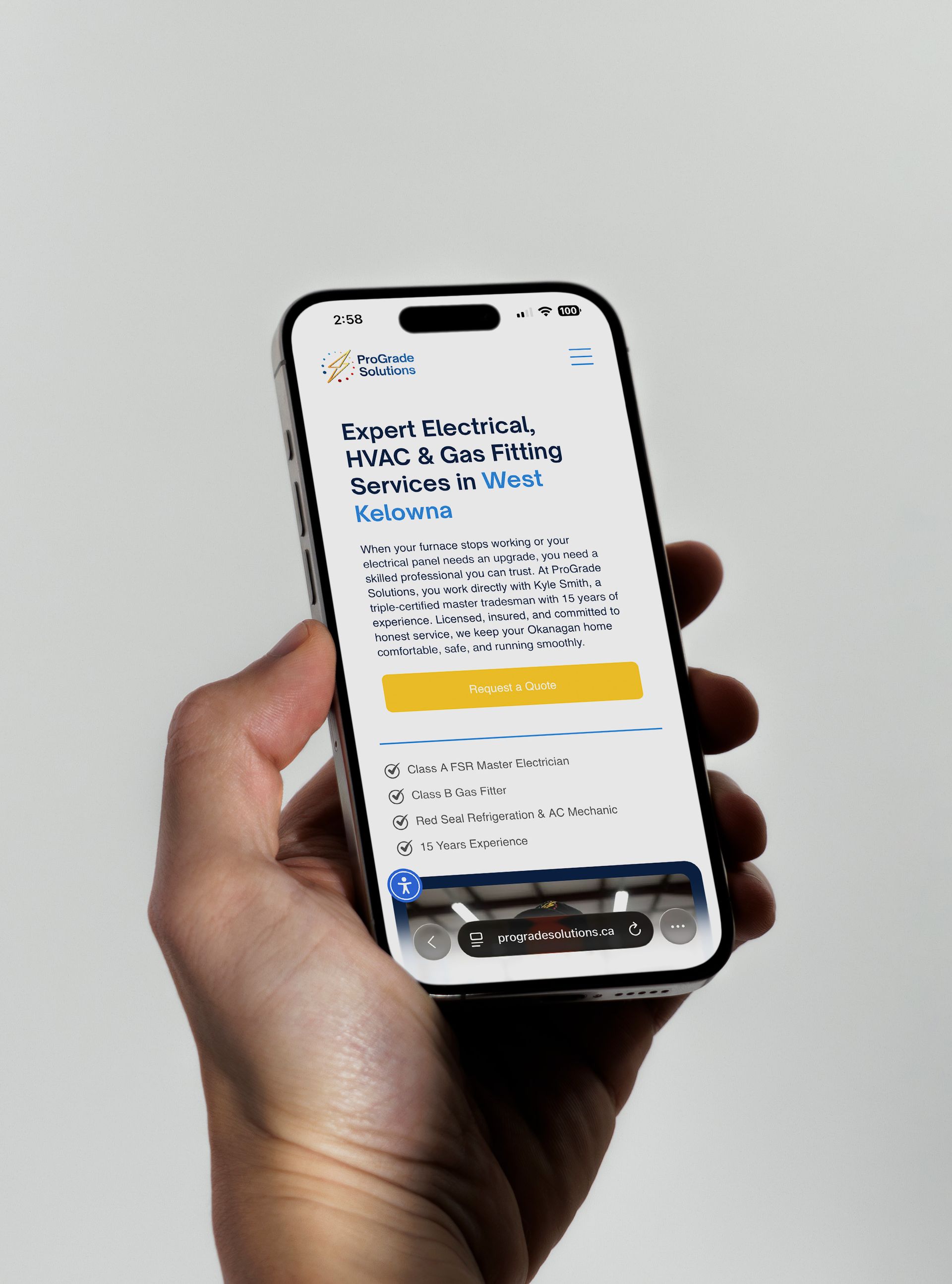 Person holding phone displaying ProGrade Solutions ad: electrical, HVAC, and gas fitting services in West Kelowna.