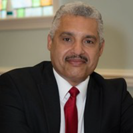 A man in a suit and tie is smiling for the camera.