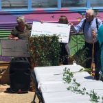 A group of people are standing around a table holding signs.