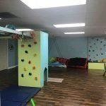 There is a climbing wall in the middle of the room.