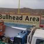 A truck is parked in front of a sign that says `` bullhead area chamber of commerce ''.