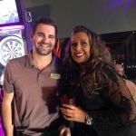 A man and a woman are posing for a picture in a bar.