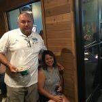 A man and a woman are posing for a picture in a restaurant.