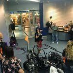 A group of people are sitting in a room with motorcycles.