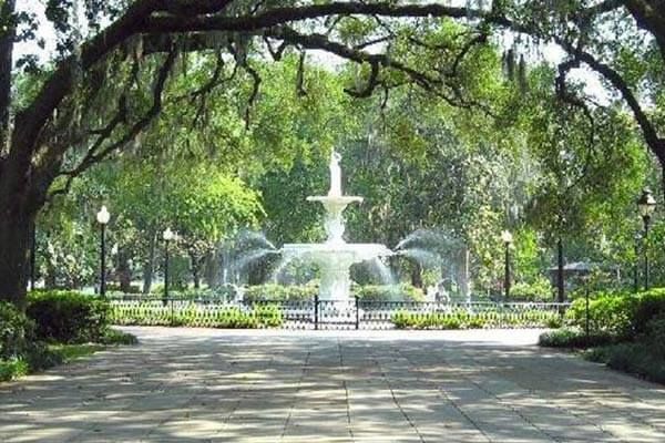 A fountain in a park surrounded by trees