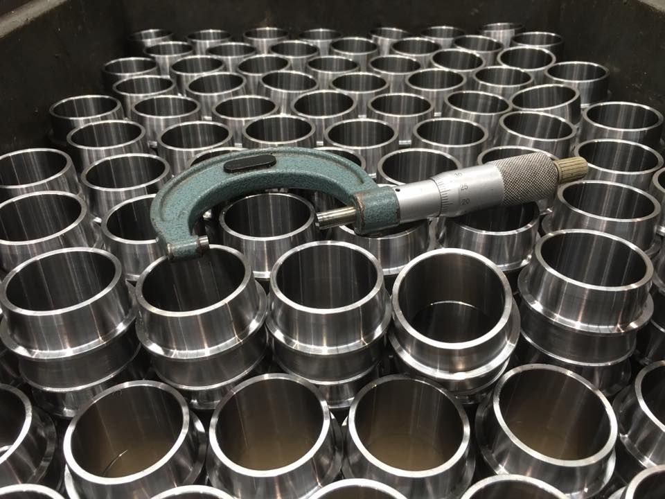 a micrometer is sitting on top of a pile of metal cylinders