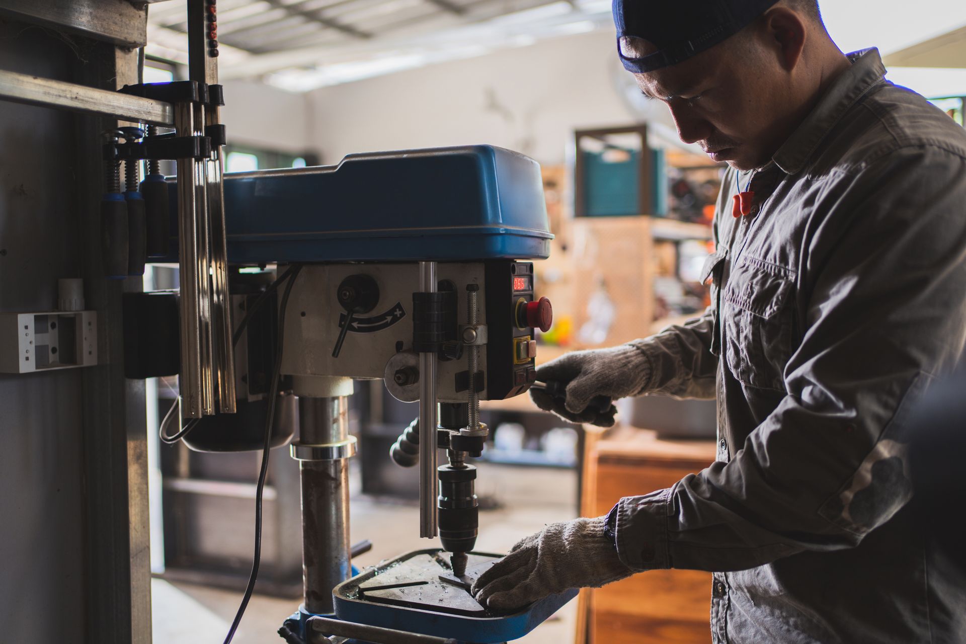 a man is working on a machine that has a red button on it