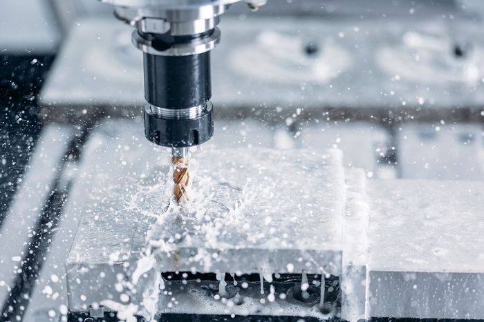 a machine is cutting a piece of metal with a drill bit