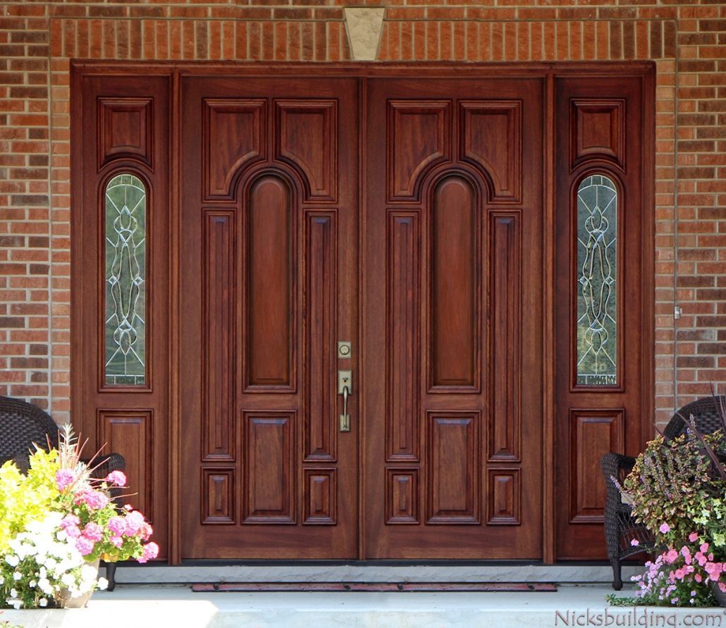 A large wooden door with a brick wall behind it