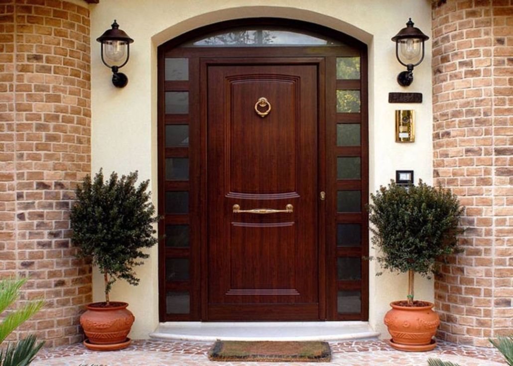 A brick building with a wooden door and potted plants in front of it