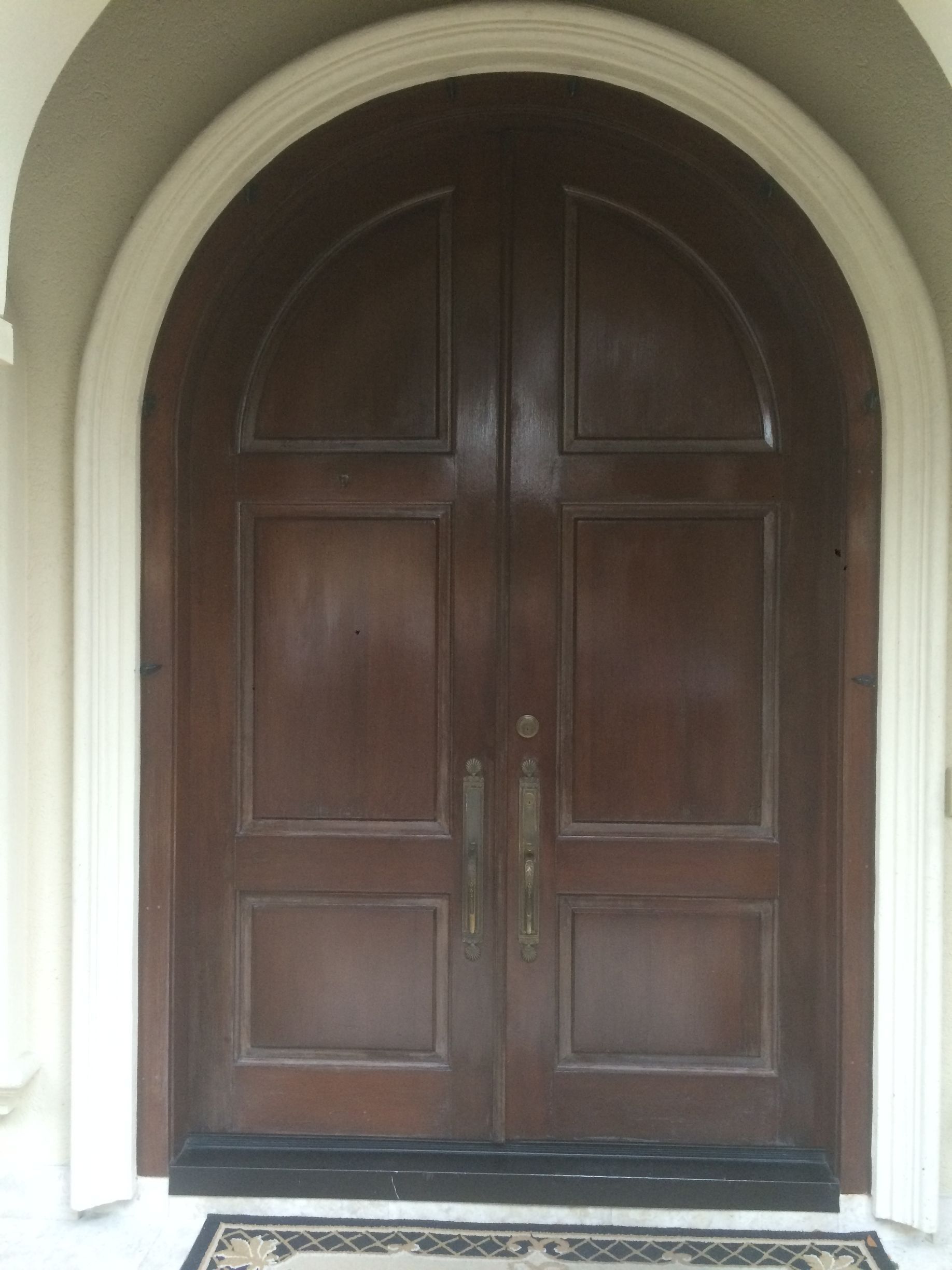 A man in blue overalls is opening a glass door.
