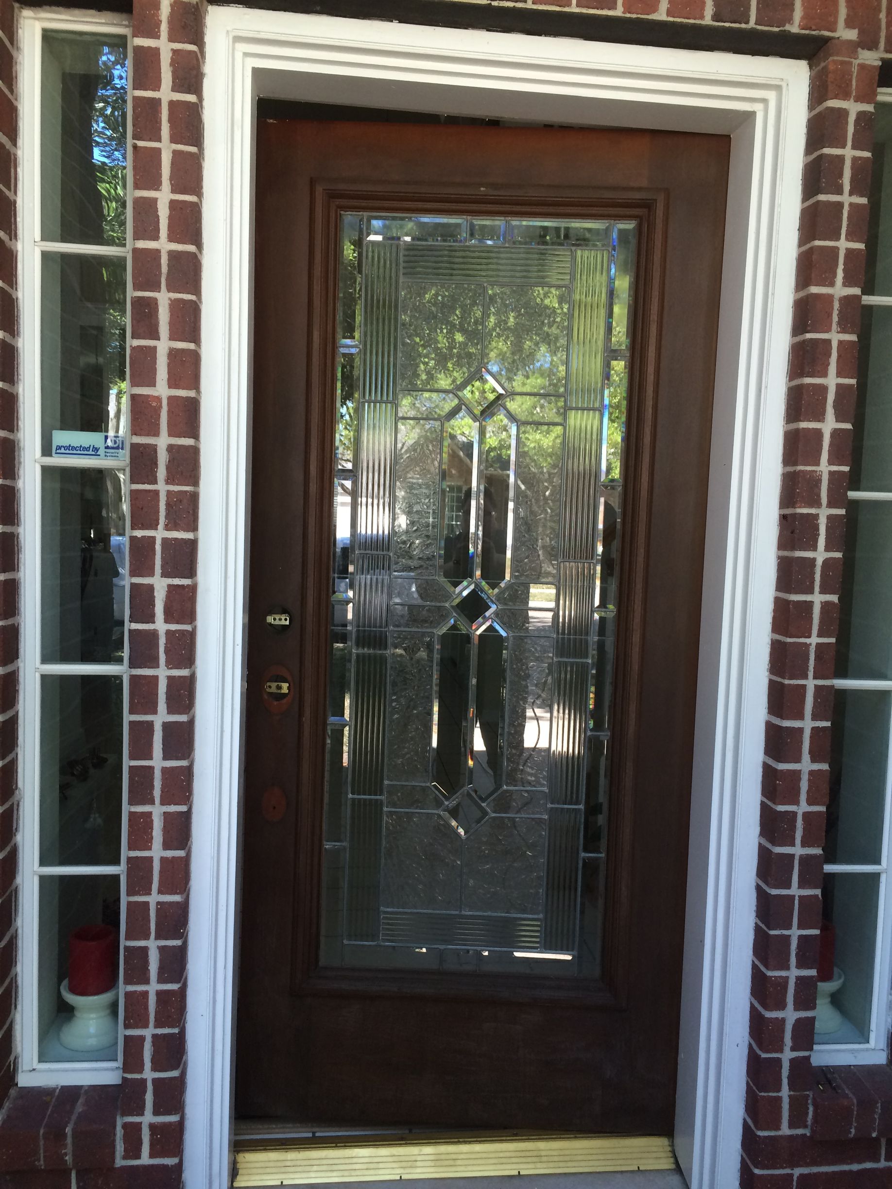 The front door of a brick house with a glass door