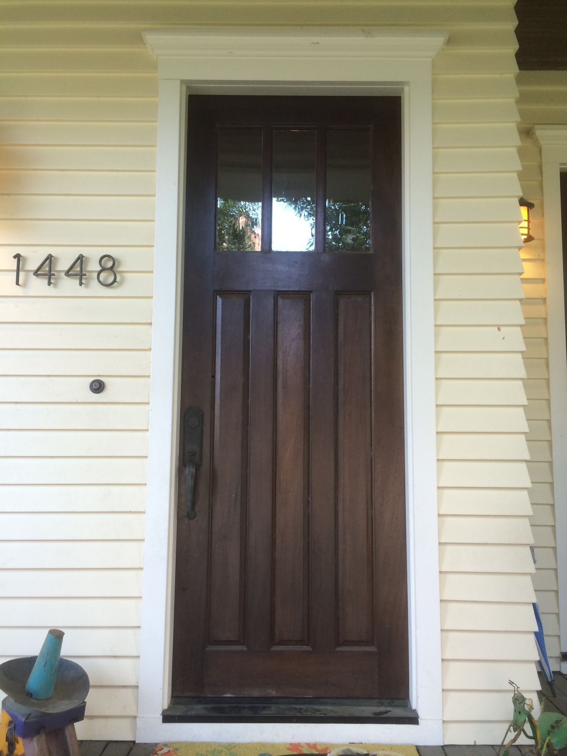 A man is installing a door lock in a living room.