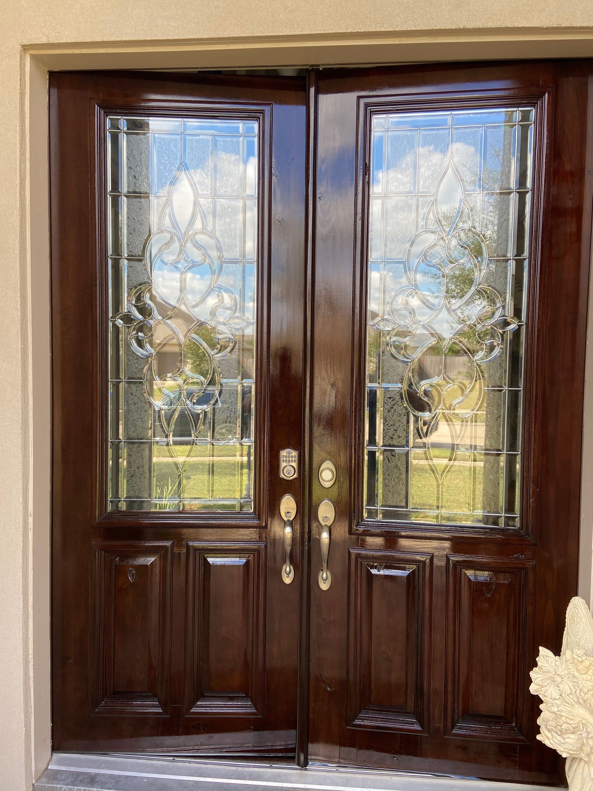 A pair of wooden doors with stained glass windows on a house.