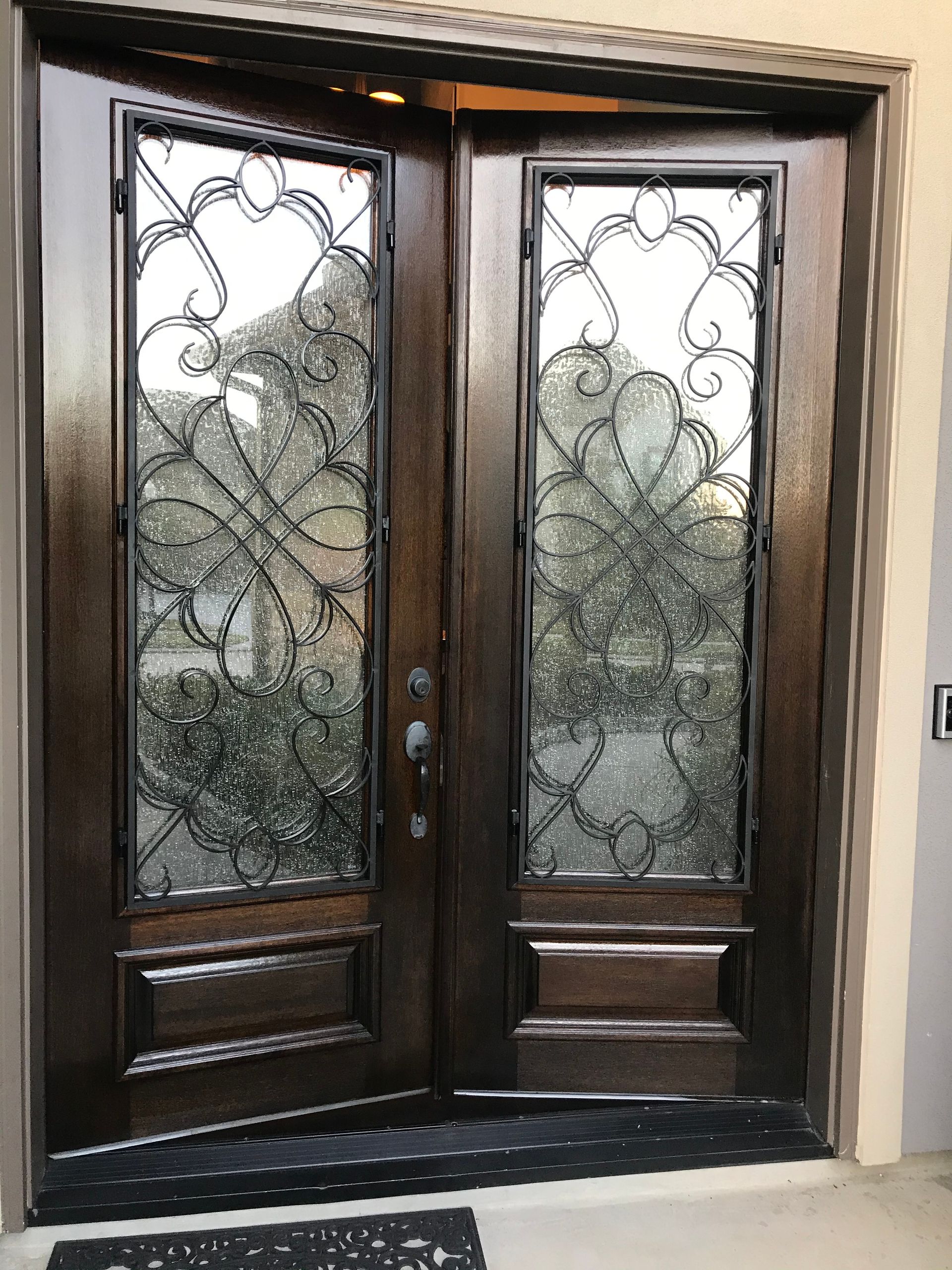 A wooden door with a wrought iron design on it