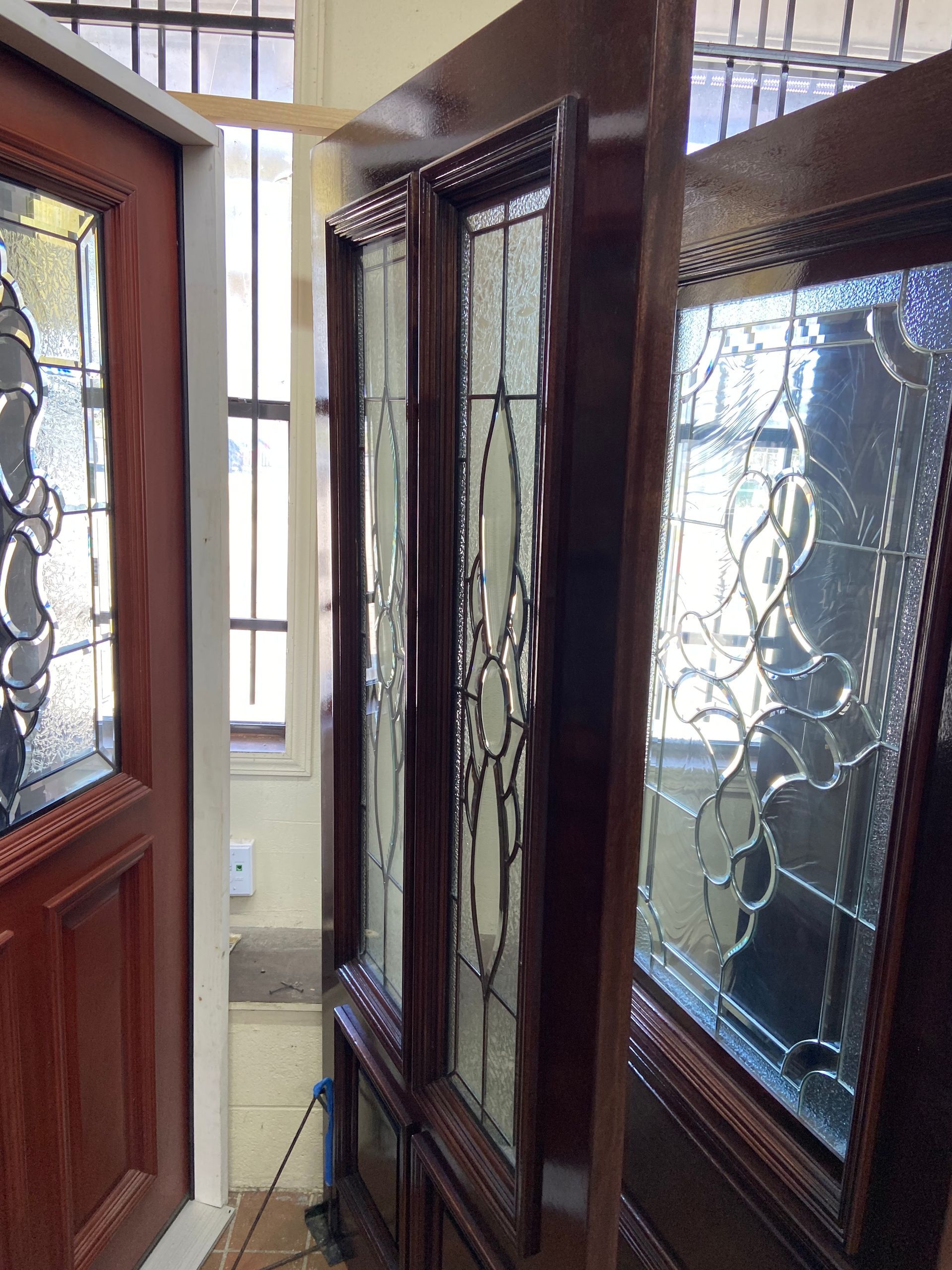A hallway with a wooden door and stained glass windows.