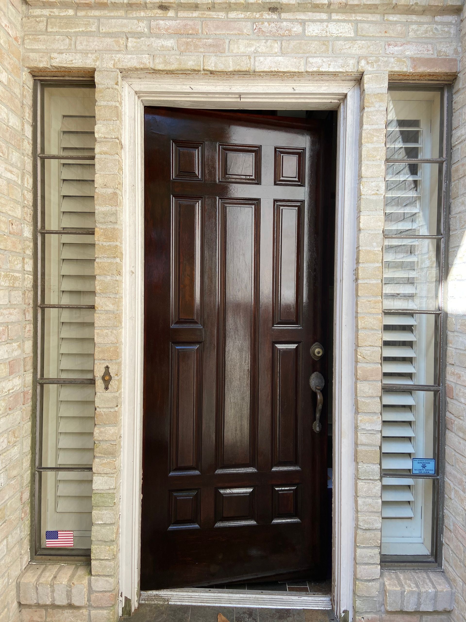 A man is fixing a door with a screwdriver.