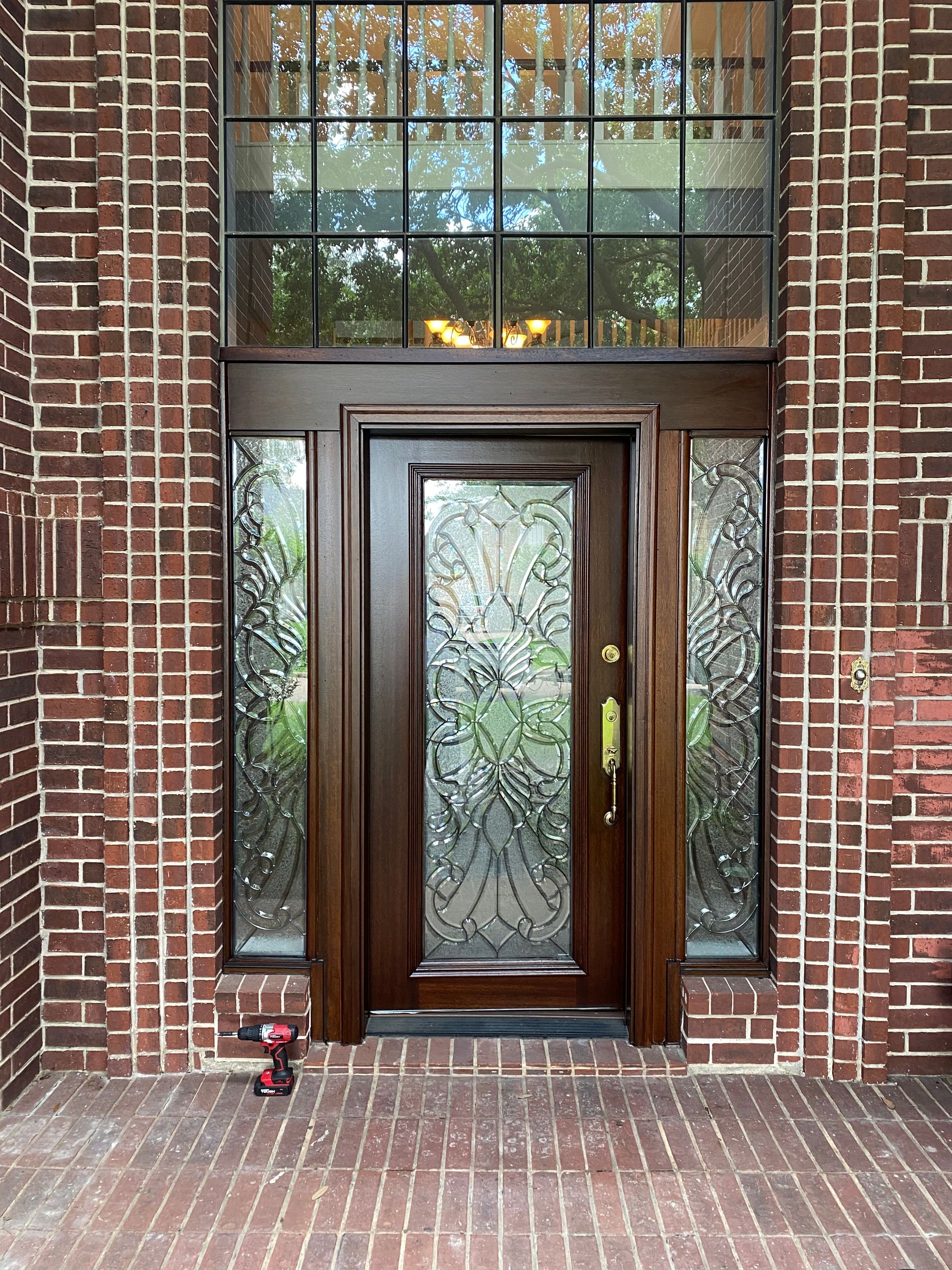 A wooden door with a wreath hanging from it and two lanterns on the side of it.