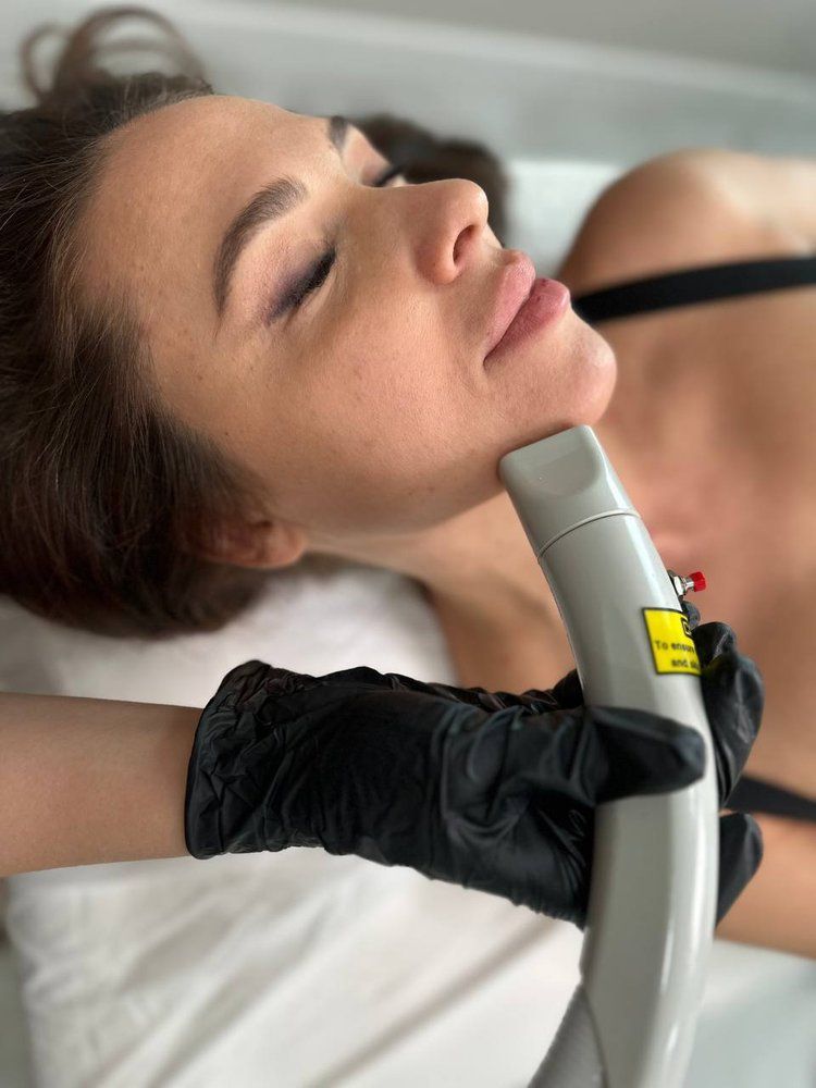 A woman is getting a laser treatment on her face.