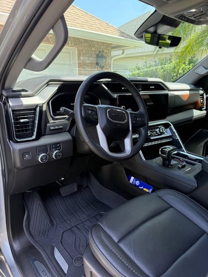 Tan leather car seats with white marks inside the interior of a car.