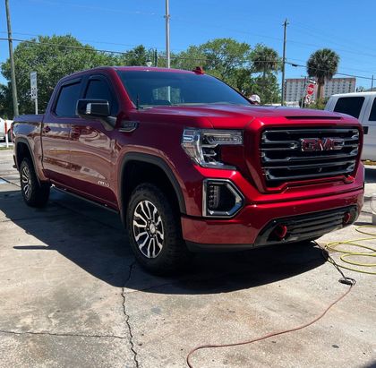 Gray Aston Martin sports car parked in a garage, front view.