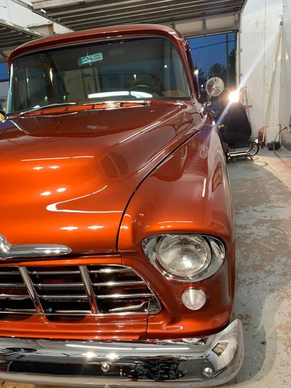 Black Mustang sports car on paved road, black rims, red calipers.