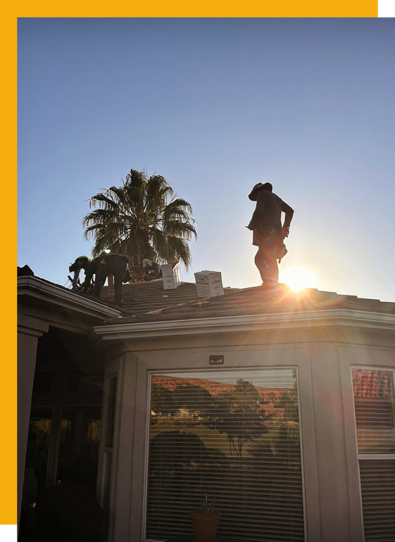A man is standing on the roof of a house.