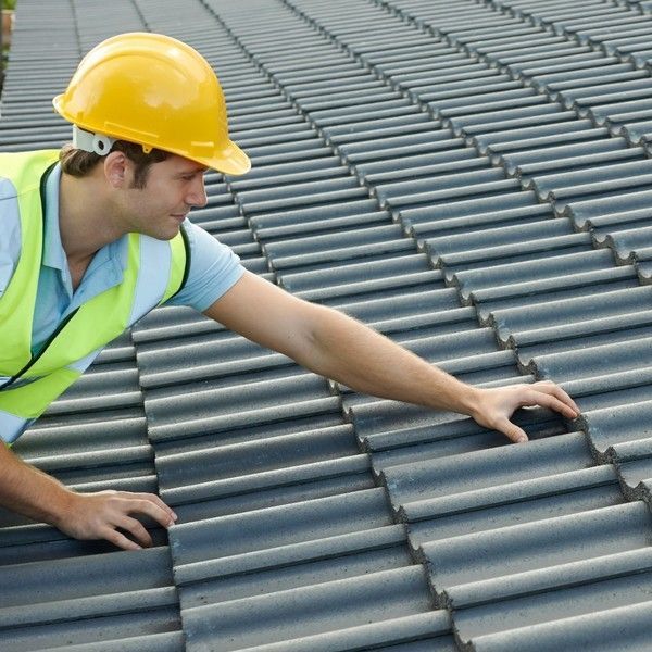A large house is being built in the middle of a dirt field.